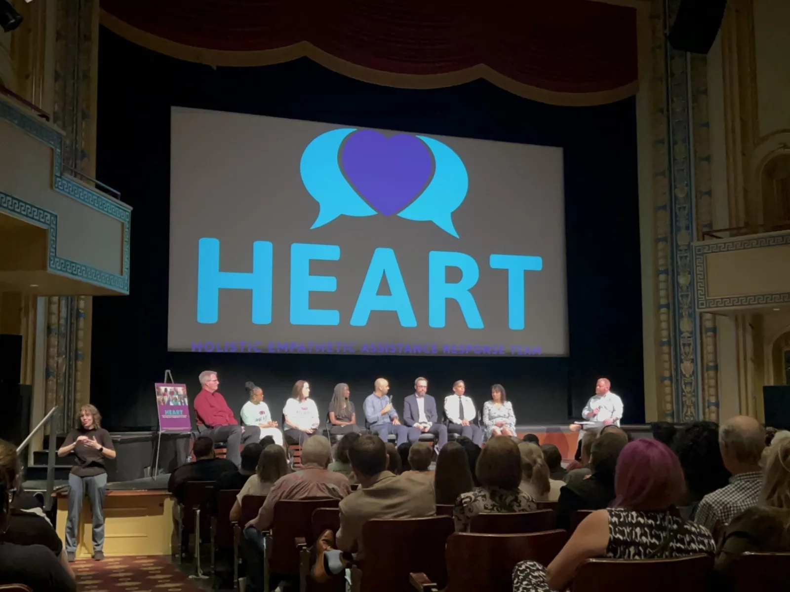 Image of speakers sitting on stage during conversation.