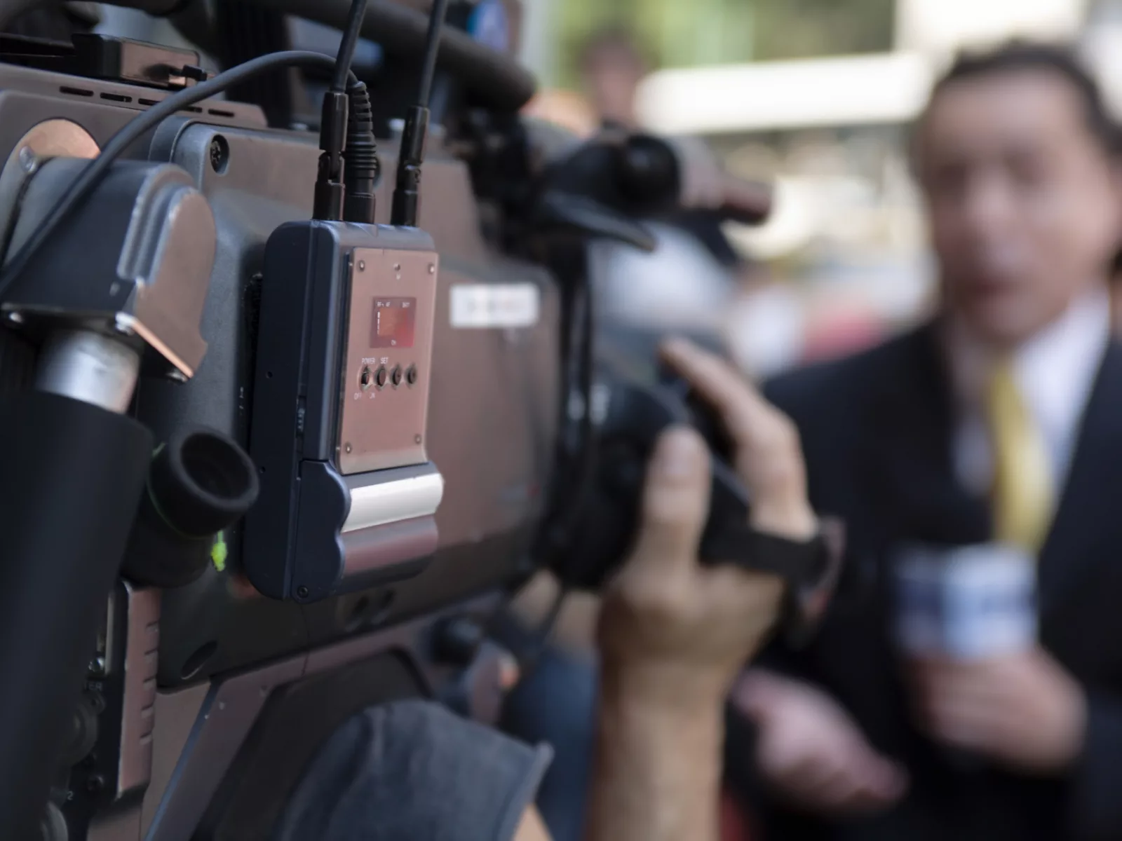 Image of news anchor speaking to camera on scene.