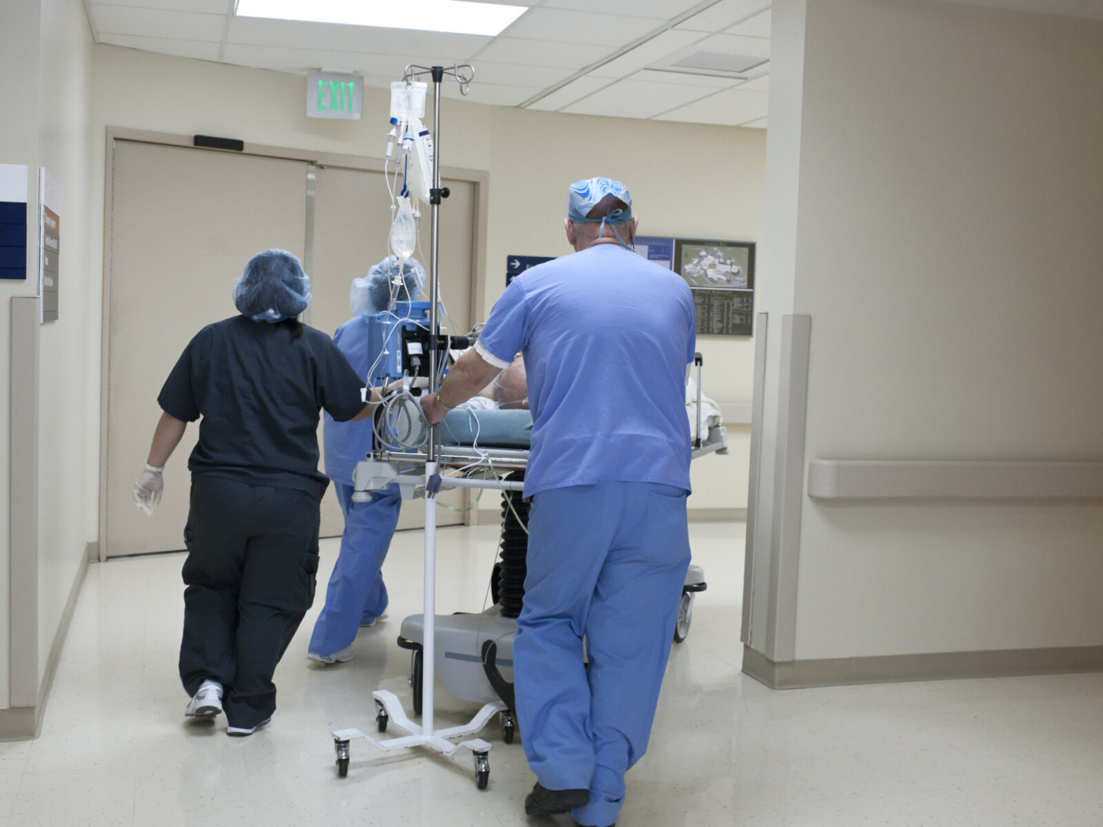 Patient being rushed through hospital corridor by medical staff.