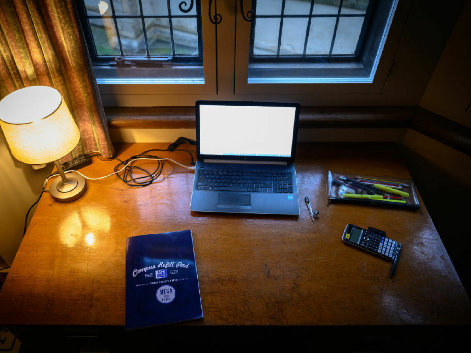Overhead view of college student's desk with lamp and laptop.