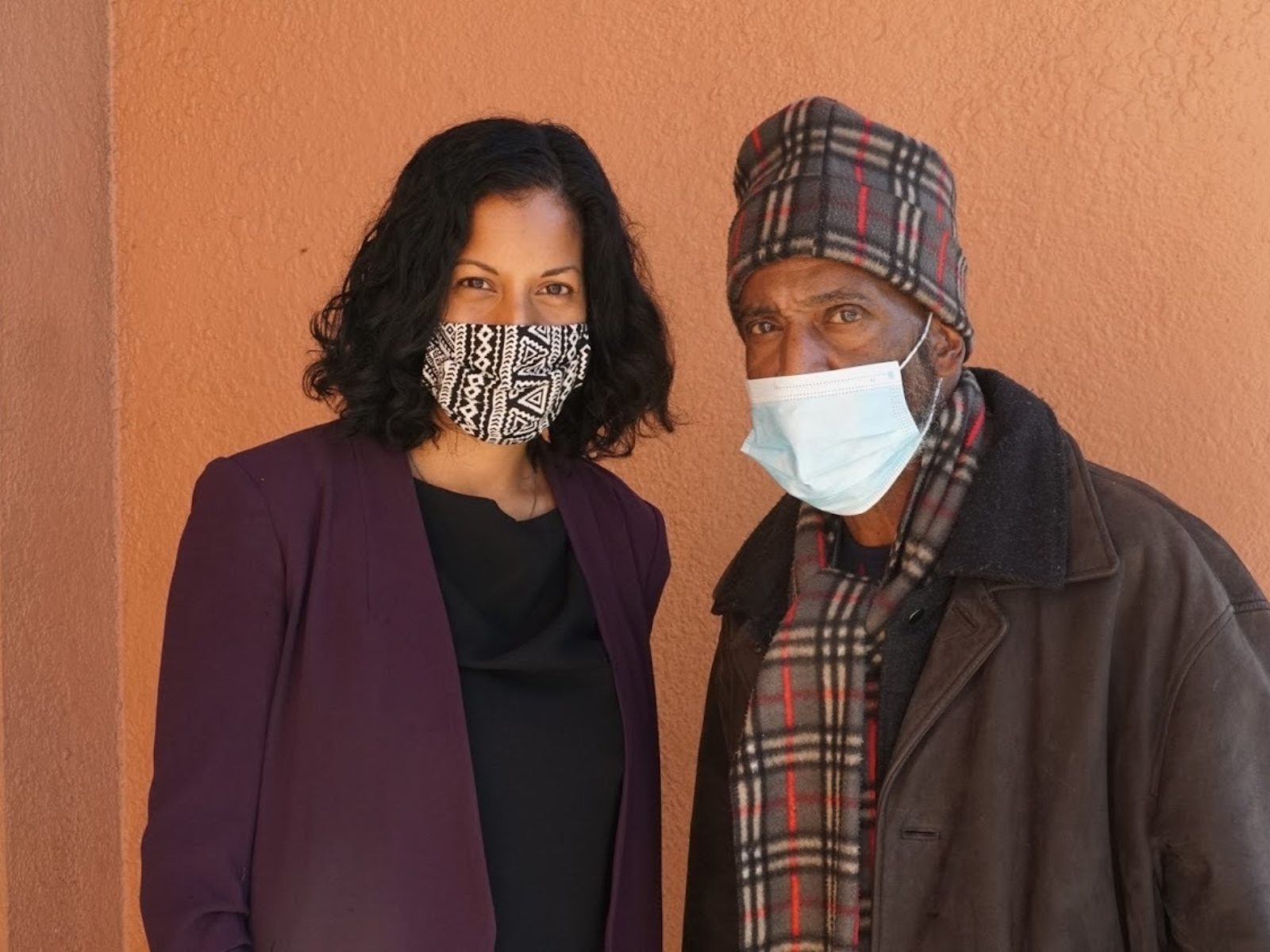 Anita Nabha and Kenneth Humphrey standing in front of an orange wall.