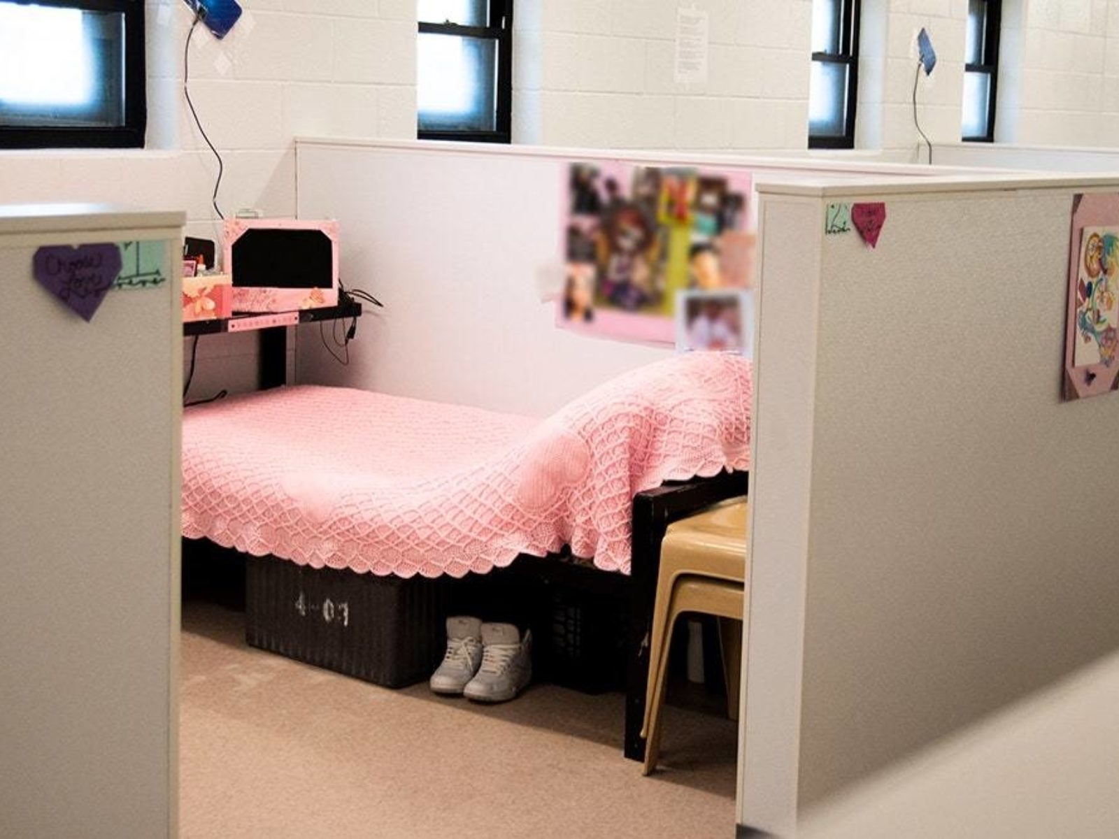A sleeping area is decorated with memorabilia and a pink bedspread.