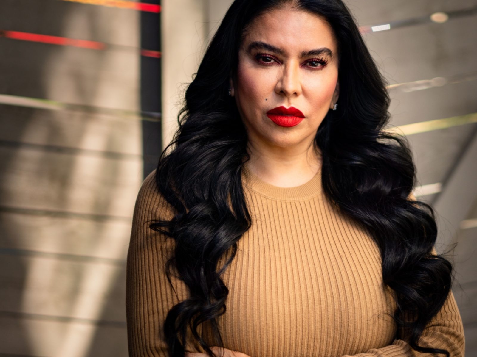 Mother Julissa Soto standing in front of a fence looking at the camera.