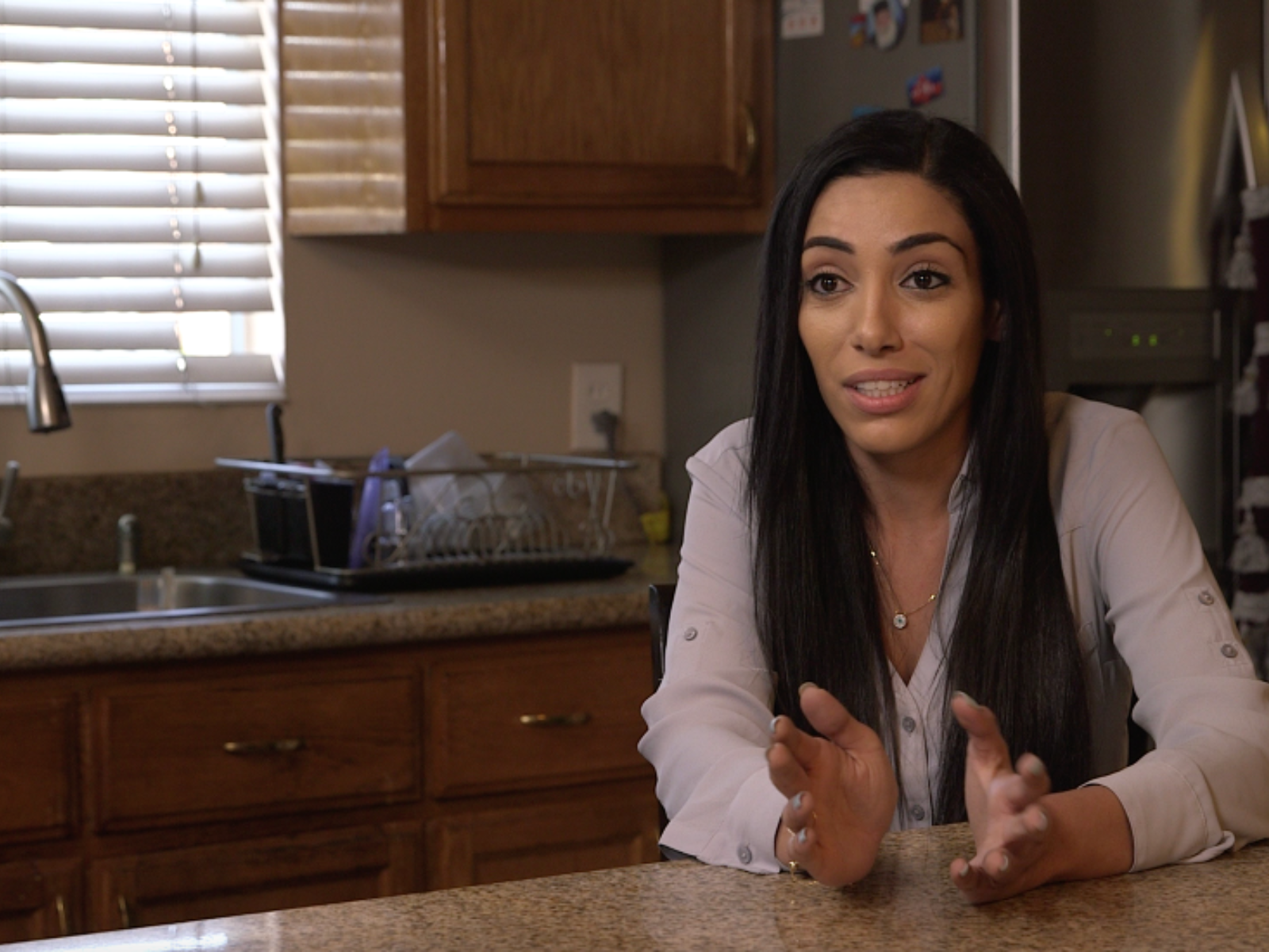 Marina Awed sitting at a table in her kitchen.