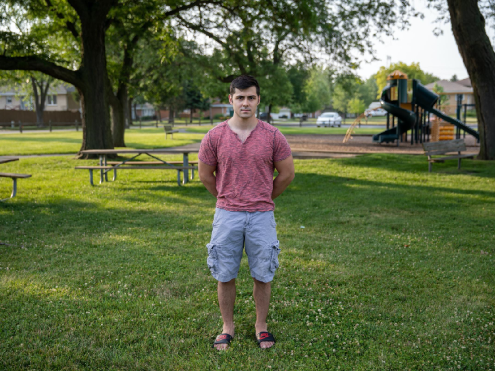 Man standing in front of outdoor playground.